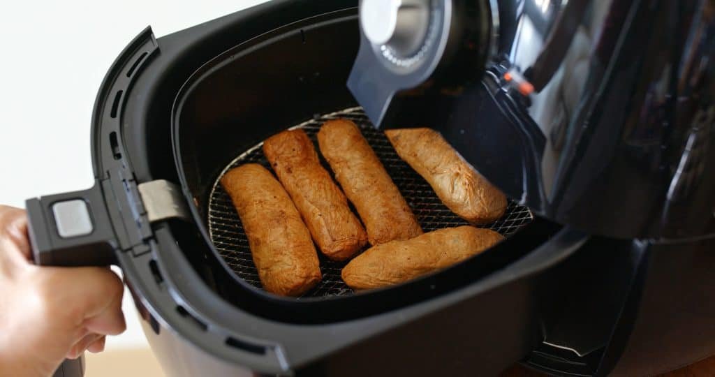 Image of vegetarian sausages being coocked in air fryeir